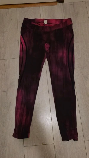 Better Bodies rosa leggings  - Säljer ett par snygga rosa och svarta tights från Better Bodies med coolt mönster och logga längs benet. De har hög midja och är tillverkade i stretchigt syntetmaterial, perfekta för träning. Tight passform och dragkedja vid benslutet.