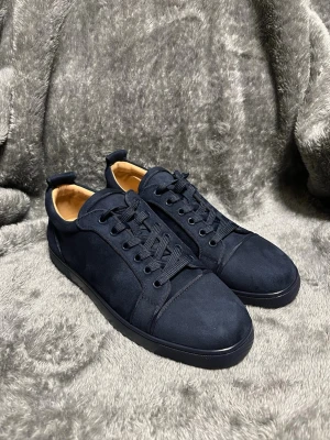 Snygga mörkblå CL  - Snygga mörkblåa sneakers med röd sula, storlek 43, aldrig använda, kommer inte med box, skriv vid frågor!