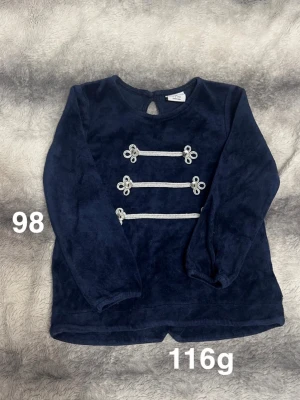 Mörkblå sammetströja med dekorsnören - Mysig mörkblå tröja i sammet från Polarn o pyret med långa ärmar och dekorativa silverfärgade snören framtill. Rund halsringning och knapp i nacken för enkel påklädning. Perfekt för dig som gillar lite extra detaljer!🌸 Fint använt skick. Storlek 98