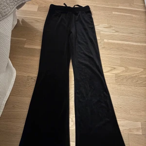 Svarta bootcut mjukisbyxor Kappahl - Säljer ett par svarta mjukisbyxor från Kappahl i storlek 164, passar som xxs-s. Byxorna har bootcut-modell, mjukt och lent material, samt bred resår i midjan med snörning för extra komfort. Perfekta för chill dagar eller när du vill ha något riktigt bekvämt. Använda ett fåtal gånger. Pris är diskuterbart vid snabb affär
