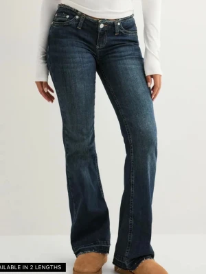 Mörkblå low waist bootcut jeans - Säljer ett helt nytt par mörkblå jeans med bootcut passform och låg midja. Jeansen har klassiska fem fickor, slitna kanter i midja.