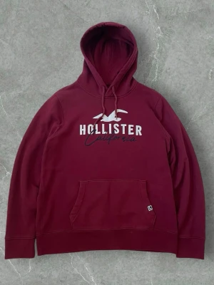 Hollister Burgundy Hoodie California – Size L - Hollister dark red/burgundy hoodie with “California” text on the front. Cozy and stylish, perfect for casual and streetwear outfits. Size Large. Good condition.
