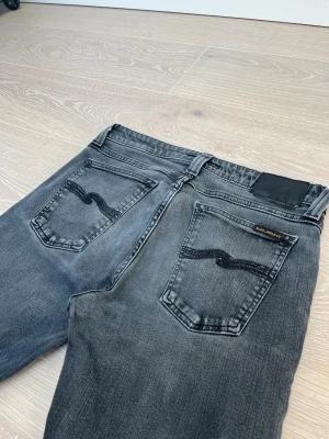 Nudie Jeans, Skinny Lin - Ett par Nudie jeans i modellen Skinny Lin, vilket är ett par Skinny jeans. Storlek W30 och L32, de har färgen Used Black. Jeansen är i ett mycket bra skick, då de inte har några defekter. Fraktar inom 24h! Hör gärna av er vid frågor!🤗