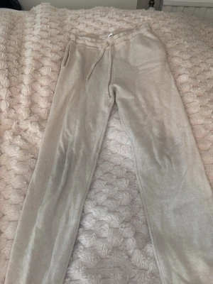 Kashmir Beige mjukisbyxor med snörning fårm soft Goat - Supermysiga beige mjukisbyxor från SOFT Goat med dragsko i midjan och fickor på sidorna. Perfekta för chill dagar hemma eller när du vill vara extra bekväm. Tillverkade i mjukt material som känns skönt mot huden.