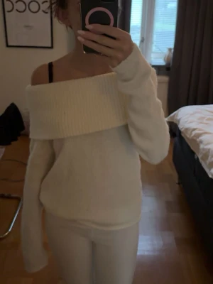 Vit offshoulder stickad tröja - vit stickad tröja med bred ribbad kant upptill som sitter offshoulder.
