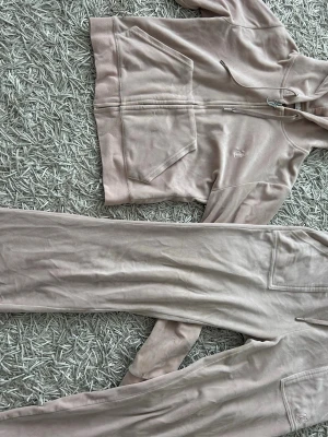 Ljusrosa mjukisset från Juicy Couture - Säljer ett ljusrosa mjukisset från Juicy Couture i mjuk sammet. Byxorna har raka ben, resår i midjan och fickor framtill och bak.