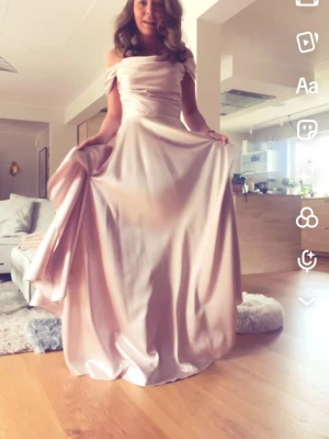 Ljusrosa balklänning - Säljer min balklänning då jag inte behöver den längre. Superfin långklänning i ljusrosa satin med offshoulder och draperad överdel. Original pris 2100. Priset kan diskuteras. Hör av er om mått osv 