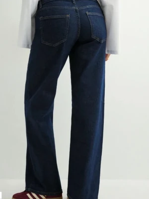 Mörkblå raka jeans med låg midja - Säljer ett par mörkblå jeans med raka ben och låg midja. Klassisk femficksmodell med snygga kontrastsömmar och knappgylf. Jeansen har en clean look och är perfekta till sneakers eller boots.