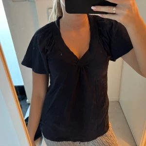 Svart blus med v-ringning - Mörkblå tröja med fina volanger, från Cubus i storlek xs 