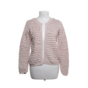 Ljusrosa stickad kofta med struktur - Superfin ljusrosa stickad kofta med unik struktur och långärmad modell. Koftan har ett coolt, fluffigt mönster över hela plagget och är perfekt för dig som vill ha något annorlunda och mysigt i garderoben.