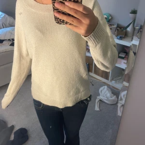 Krämvit stickad tröja med rund hals - Enkel och snygg krämvit stickad tröja med rund halsringning och ribbade muddar. Tröjan har en avslappnad passform och långa ärmar, perfekt för lager på lager under kyligare dagar. Väldigt nopprig 