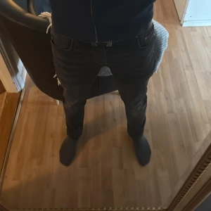 Jack&jones jeans - Säljer ett par svarta jeans med riktigt smal passform och klassisk femficksdesign. Jeansen har låg midja och är tillverkade i stretchigt denim som sitter tajt längs benen. Perfekta för dig som gillar en modern och stilren look.