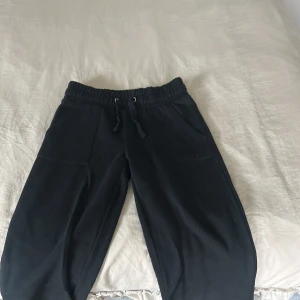 Svarta mjukisbyxor XS från 157 - Svarta mjukisbyxor från 157 i storlek XS. Byxorna har resår och snörning i midjan, stora fickor fram och bak samt en loose passform. Använda enstaka gånger