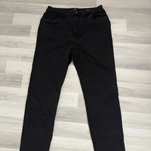 Svarta Curvy Stretch Jeans från Cotton On - Svarta jeans från Cotton On i modellen Curvy Stretch Straight Jean. Byxorna har rak passform men också lite åt skinny sidan. Har haft på mig ett par gånger. Nytt pris 650kr