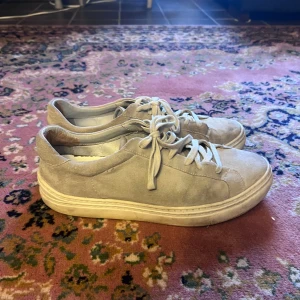 Beige mockasneakers från Massimo Dutti 43 - Snygga beige sneakers från Massimo Dutti i mjuk mocka med klassisk rund tå och platt vit sula. Skorna har snörning och stilren design som passar till det mesta. Perfekta för dig som gillar en clean och enkel look.