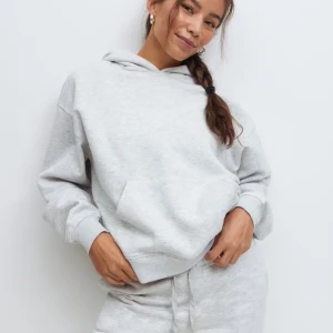 Ljusgrå hoodie  - Säljer en stilren ljusgrå hoodie med huva och magficka. Tröjan har en relaxed passform och är tillverkad i mjuk bomullsblandning. Perfekt för chill dagar och enkel att matcha med andra plagg. Den är sparsam använd. Köptes för 369 säljer för 269