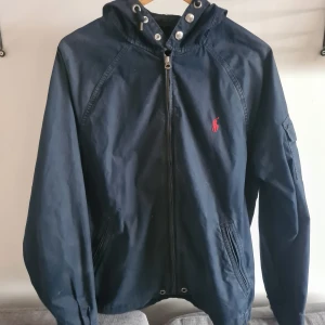 Ralph Lauren jacka  - Mörkblå vindjacka från Polo Ralph Lauren i storlek M. Den är I mycket bra skick och passar perfekt till hösten. Hör av dig vid frågor!