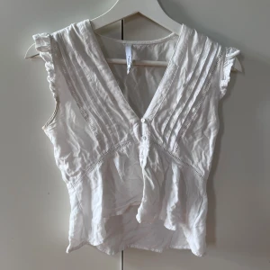 Vit blus - Fin vit blus från Portugal. Köptes för 500. En liten fläck på men annars rätt fin. Kan inte visa hur den sitter på då den är lite liten!! Pris kan absolut diskuteras 