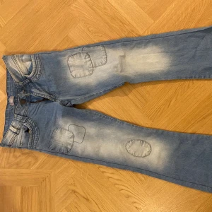 Lågmidjade vintage jeans - Köpte secondhand men tyvärr för små🥹🥹Snygga ljusblå jeans från F&F med coola patchdetaljer på benen och slitna partier. Stor knapp och lågmidjade💗