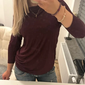 Vinröd långärmad topp - Säljer en jättesnygg vinröd långärmad topp med draperad halsringning. Modellen är rak och lite loose fit. Säljer då den inte kommer till användning. Vet inte vart den är ifrån. Aldrig använd, pris kan diskuteras!