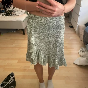 Grön blommig kjol - Säljer denna somriga kjol då den är lite liten. Nästan aldrig använd. 