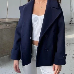 Mörkblå designe by si kapp - Stilren mörkblå kappa från design by si i bra skick, nypris 757kr! Stolek xs/s