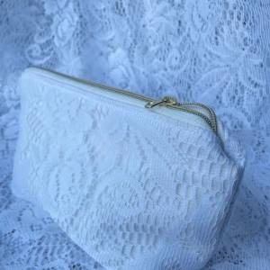 Vit spets necessär/väska - Vit spets med guldig dragkedja✨🤍.                      Produkten är av helt återanvänd textil, för miljöns skull♻️                                                     Mått: 16x12x7cm                                                             179kr +frakt, du som köpare står för frakten