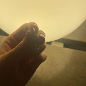 Guldiga örhängen med spetsig detalj - Säljer ett par coola guldiga örhängen med rund form och hängande spetsig kon-detalj. De har en enkel men edgy design som verkligen sticker ut. Perfekta för dig som vill ha något unikt och trendigt i smyckeskrinet.