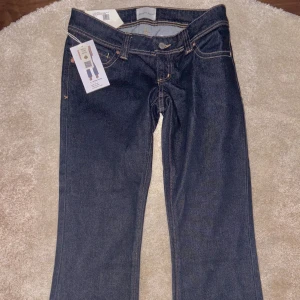 Abrand mörkblå lågmidjade bootcut jeans - Helt nya oanvända Mörkblå jeans från Abrand med låg midja och bootcut-snitt. Klassisk femficksmodell med kontrastsömmar och liten utsvängning från knäna. Tillverkade i kraftigt denimtyg för en tidlös look.