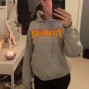 Grå Thrasher hoodie - Säljer en grå hoodie från Thrasher. Tröjan har huva med snörning och en magficka. Det står inte vilken storlek det är på tröjan men jag skulle säg en S/M ☺️Jag köpte den ny för 800kr 