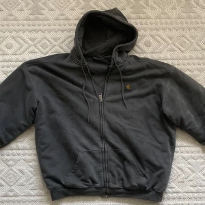 Grå Carhartt vintage jacka. - Säljer en grå jacka från Carhartt i bra skick. Den har en dragkedja framtill och en praktisk huva. Perfekt för höst och vinter, och passar till både vardag och chill. I storleken M. Hör av dig vid intresse!