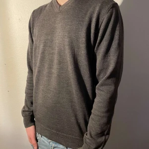 Oscar Jacobson - Säljer en stilren grå tröja från Oscar Jacobson i storlek S-M Tröjan har en v-ringad design och är tillverkad i ett mjukt material som passar perfekt för kyligare dagar. Perfekt för dig som gillar klassisk stil.