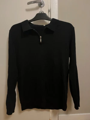 Svart pikétröja med zip - Säljer denna långärmade halft-zip tröjan efter som den inte kommer till användning. Vet tyvärr inte vart den är köpt. Den är i mycket bra skick och inte använd särskilt mycket. Priset går att diskuteras! 