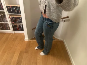 Lågmidjade bootcut jeans - Säljer dessa blåa Lågmidjade jeans, as snygga men ska flytta till Spanien sä tänkte sälja nästan alla jeans. Jeansen har snygga broderade detaljer på bakfickorna, kontrastsömmar och nitar vid fickorna. Vet ej storlek men gissar runt 27/32, 28/32💕