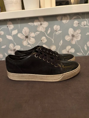Svarta sneakers från Lanvin - Snygga svarta lanvins som ja köpte i somras av min kompis, han hade beställt dom och använt dom under båt veckan sen sålt dom till mig. Jag håller efter dom och skorna är i fint skick de ända dåliga är ett litet märke på toe boxen som man ser på sista bilden annars är dom typ helt nya  Säljer till rätt pris!