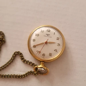 Vintage Technos pocket watch - My grandmother's pocket watch she used as a nurse in Kalmar for many years from 1972. The watch is fully functional and hold time well so long as you keep it wound. The watch has minor signs of wear, but the chain has obvious signs of wear. The chain is about 92cm and can be worn as a necklace. The watch is about 3x4cm.  Bundle discounts: two items 10% off (automatic) three items 15% off, five items 20% off. Message me before purchasing 3+ items for discount.