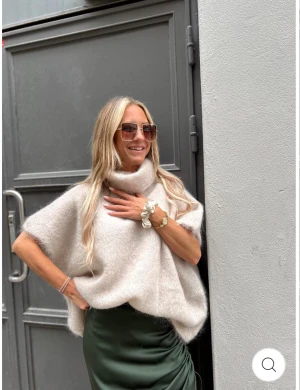 Roro mohair beige polo - Supermysig och fluffig beige polotröja med oversized passform. Tröjan har korta ärmar och är tillverkad i mjuk ull som ger en lyxig känsla. Perfekt för lager-på-lager och passar snyggt till både jeans och kjol. Polokragen är bred och ger extra värme.