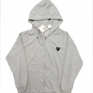 Ami Paris  - Ami Paris zip-up hoodie i grått i nyskick. Stilren design med ikonisk Ami de Cœur-logotyp på bröstet. Mjuk och bekväm kvalitet, sparsamt använd och utan slitag