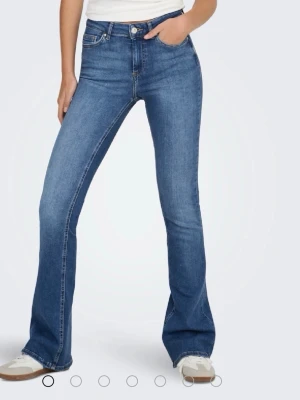 Blå bootcut jeans med hög midja - ONLBLUSH MID FLARED REA1319 NOOS  köptes för 550kr. Sitter jättebra där bak och formar fint.  Jag har tagit bort prislappen men byxorna är helt nya, har aldrig använt dem. Säljs på grund av garderob rensning (flytt) 