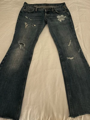 Lågmidjade bootcut jeans  - Lågmidjade bootcut jeans med revor/hål 🤍ser lite mörkare i på bild än i verkligheten! 