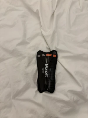 Monolit pennvässare i svart - Säljer en svart pennvässare från Monolit med cool, ergonomisk form och tydliga markeringar för längd. Perfekt för att vässa sminkpennor som ögonbrynspenna eller läppenna. Materialet är plast med en snygg finish. Endast en benskydd!