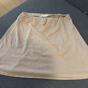 Beige mockakjol från NLY Trend - Säljer en enkel och söt beige kjol från NLY Trend i mjuk mockaimitation. Kjolen har resår i midjan och en rak, kort passform som är lätt att matcha med olika toppar. Perfekt för dig som gillar söta plagg med en mjuk känsla.