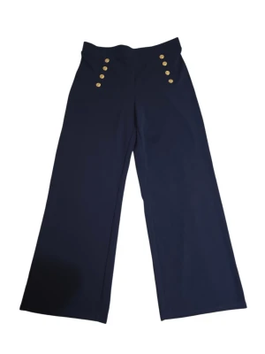 Mörkblå wide byxor med guldknappar - Snygga mörkblå byxor med hög midja och breda ben. Framtill sitter sex guldiga knappar som cool detalj. Perfekta för dig som gillar en trendig och stilren look. Materialet känns mjukt och följsamt. Fåtal gånger använda