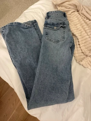 Blå jeansbyxor från 157, storlek XS - Säljer ett par klassiska blå jeansbyxor från 157 i storlek XS med full längd. Jeansen har knäpp fickor och utsvängda ben , tillverkade i slitstarkt bomullsmaterial. Perfekta för dig som gillar enkel och tidlös denimstil.