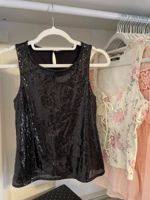 Svart paljettlinne - Svart linne med glittriga paljetter perfekt till nyår! Passar XS. 