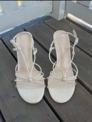 Klackar - Snygga beige sandaler med smala remmar och öppen tå från Boohoo. Skorna är breda och klacken är 9,5cm. Helt nya och oanvända! Perfekt till sommaren