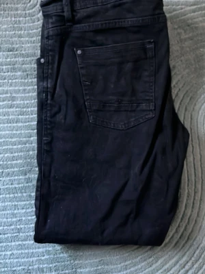 Svarta slim jeans från twister  - Säljer ett par svarta Levis jeans med klassisk femficksdesign och smal passform. Jeansen har en enkel look utan synliga detaljer och är tillverkade i mjukt bomullsmaterial med lite stretch. Perfekta till vardags för en clean och stilren outfit.