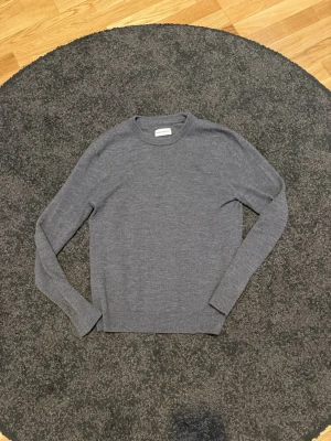 Grå merinoulltröja  - Säljer min brorsas gamla merinoull tröja från Volt/these glory days. Tröjan är i bra skick och säljs därför att den blivit för liten 