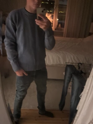 Grå stickad tröja från Polo Ralph Lauren - Snygg grå stickad tröja från Polo Ralph Lauren med rund halsringning och diskret broderad logga på bröstet. Tröjan har ribbstickade muddar vid ärmslut och nederkant. Perfekt för lager-på-lager och enkel att matcha.