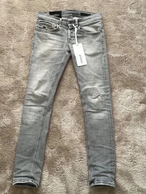 Dondup George - Säljer ett par ljusgråa dondup George i st 29. Endast använda vid fåtal tillfällen, därefter inga tecken på användning. Inköpta för ungefär 3600  på butiken W19 i Göteborg, kan gå ned i pris snabb affär. Kontakta vid frågor!    Tags finns säkert, behöver bara ta fram isf